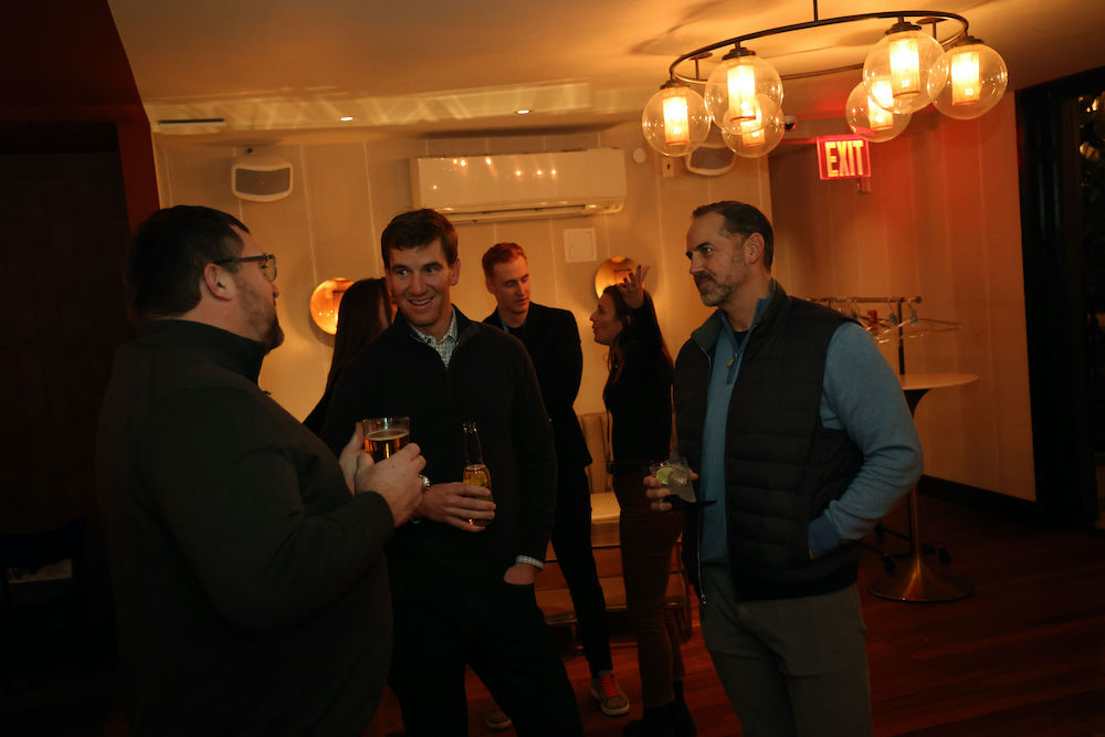Eli Manning in conversation at corporate networking event