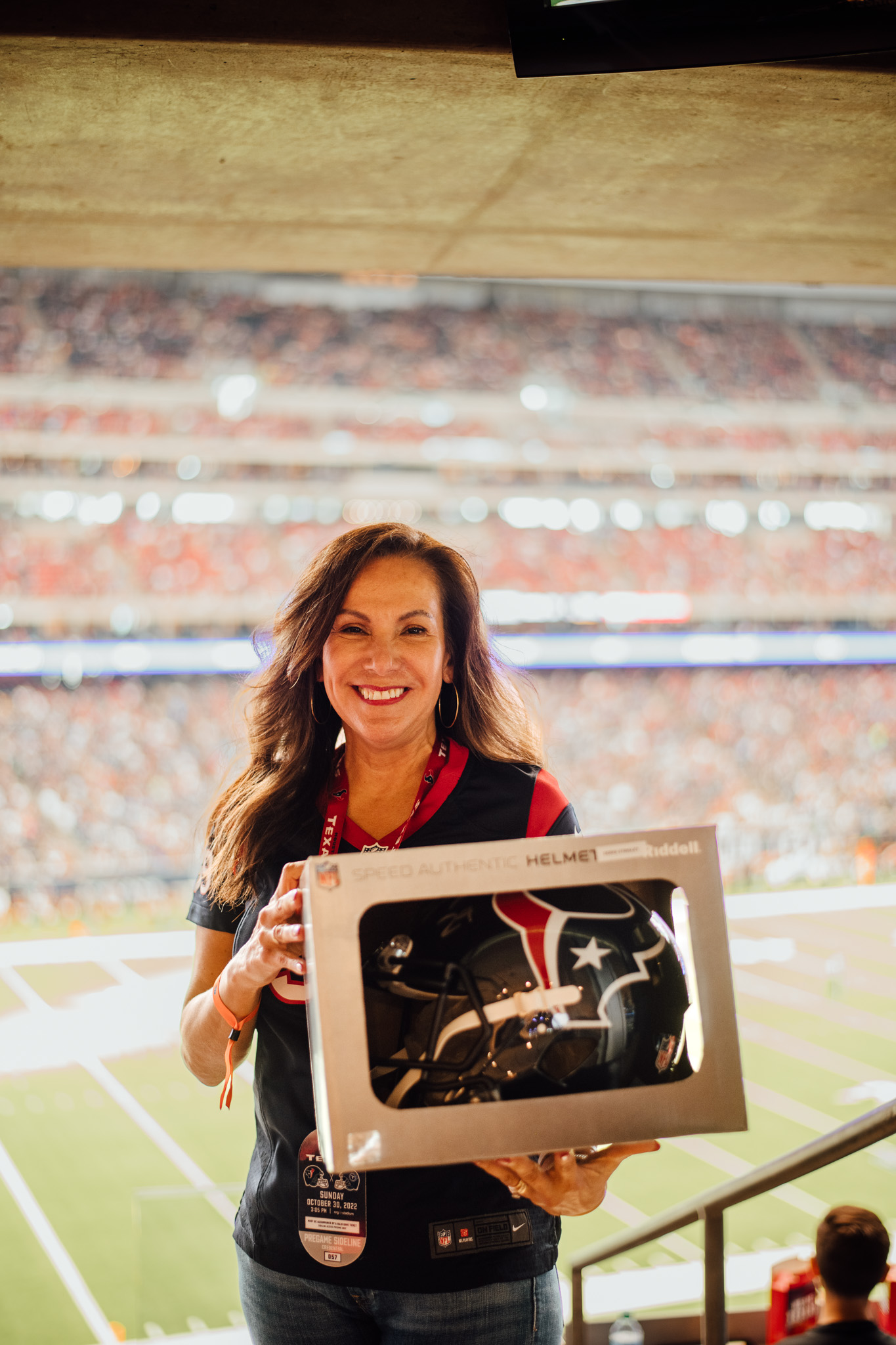 woman holding Texans helmet at an NFL game